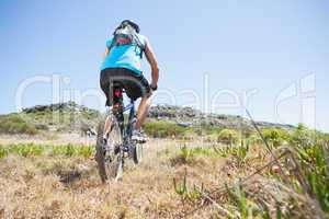 Fit cyclist riding in the countryside uphill