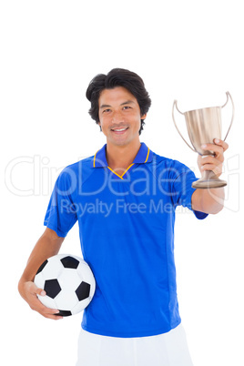 Football player in blue holding winners cup