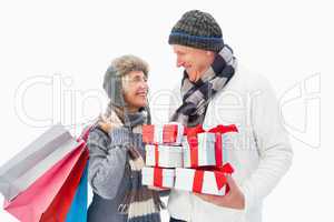 Mature couple in winter clothes holding gifts