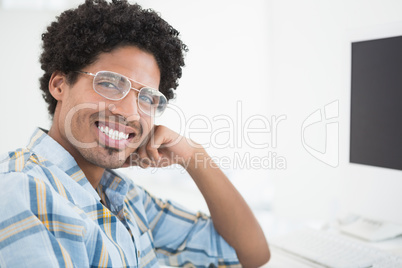 Young casual businessman smiling at camera