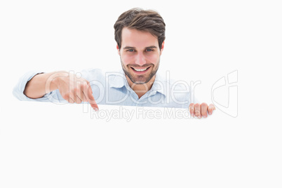 Attractive young man smiling and holding poster