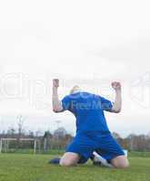 Football player in blue celebrating a victory