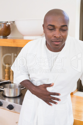 Sick man in bathrobe clutching stomach