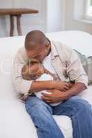 Happy father spending time with baby on the couch