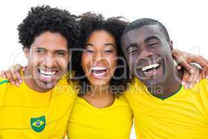 Happy brazilian football fans in yellow smiling at camera