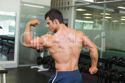 Rear view of a muscular man flexing muscles