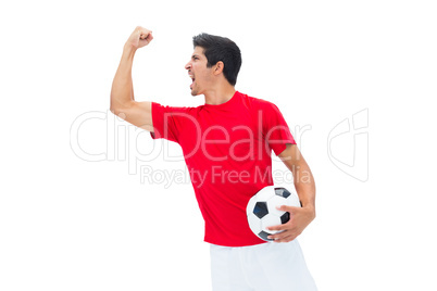 Football player in red holding ball and cheering