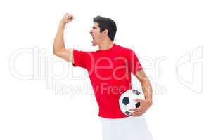 Football player in red holding ball and cheering