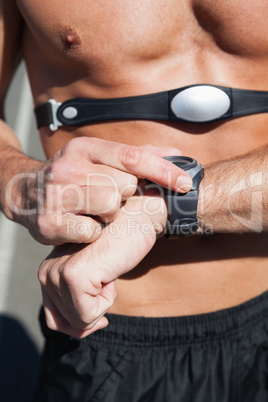 Athletic man on open road with monitor around chest