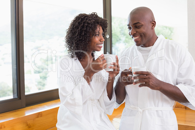 Happy couple having coffee together in bathrobes