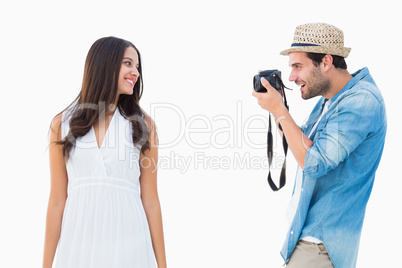 Handsome hipster taking a photo of pretty girlfriend