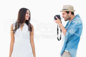 Handsome hipster taking a photo of pretty girlfriend