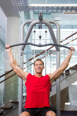 Strong man using weights machine for arms