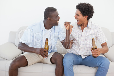 Football fans cheering and holding beer bottles