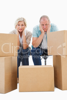 Stressed older couple with moving boxes