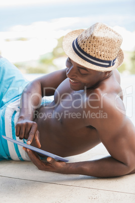 Happy shirtless man using his tablet pc