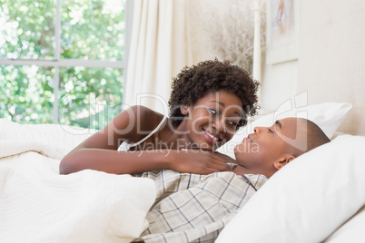 Happy couple lying in bed cuddling