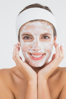 Attractive woman having white cream on her face