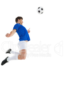 Football player in blue jersey jumping to ball