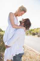 Attractive man lifting up his girlfriend