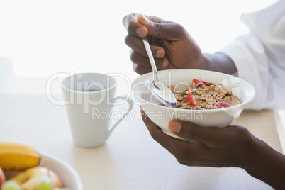 Man eating bowl of cereal outside