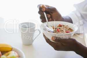 Man eating bowl of cereal outside