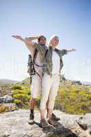 Hiking couple standing on mountain terrain admiring the view