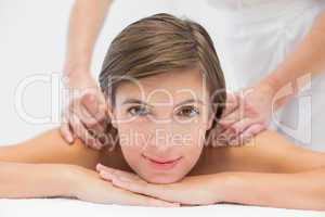 Attractive woman receiving shoulder massage at spa center