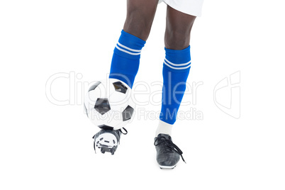 Football player in blue socks kicking ball
