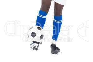 Football player in blue socks kicking ball