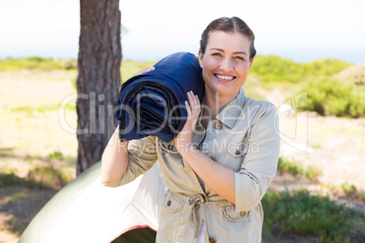 Outdoorsy woman smiling at camera outside her tent
