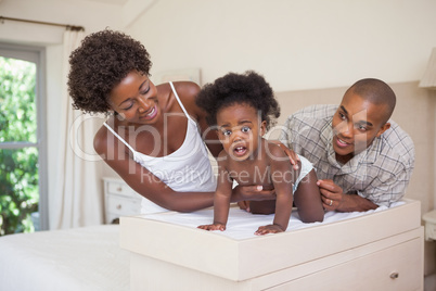 Happy parents with their baby girl on changing table