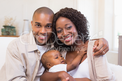 Happy parents spending time with baby on the couch