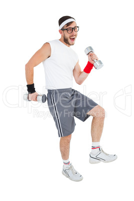 Geeky hipster lifting dumbbells in sportswear