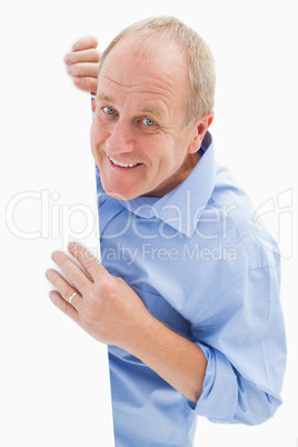 Mature man smiling at camera around card