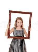 Pretty girl holding picture frame.