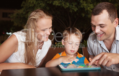 Family of three spending time in cafe with tablet computer