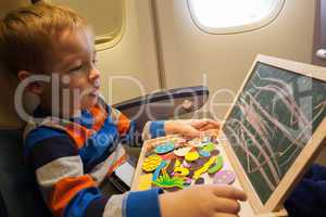 Boy in the plane drawing on board with chalk