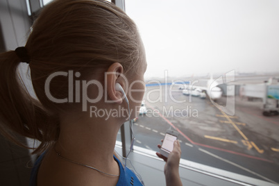 Woman in headphones looking at aiport area