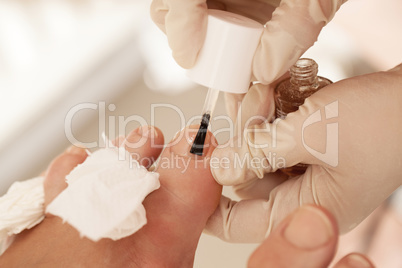 Applying nail polish during pedicure at beauty spa