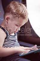Little child using touch pad while traveling by bus