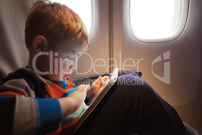 Child using tablet computer during flight