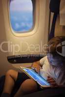 Boy spending time with tablet PC during flight