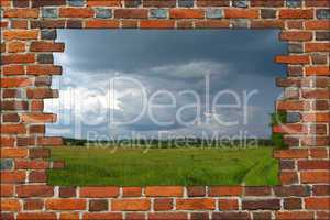 broken brick wall and view to field with thunder