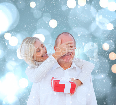 Composite image of woman surprising man with gift