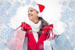 Composite image of beautiful festive woman holding shopping bags