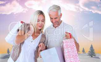 Composite image of happy couple with shopping bags