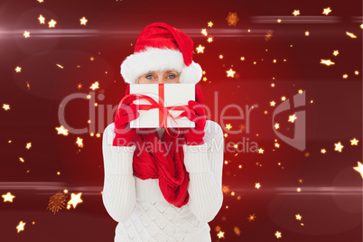 Composite image of festive woman holding gift