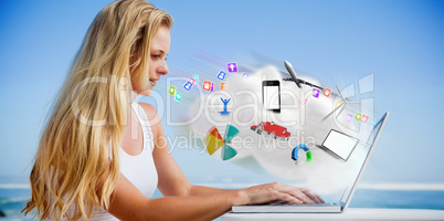 Composite image of pretty blonde using her laptop at the beach