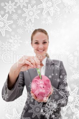 Composite image of money being put into piggy bank by smiling ba